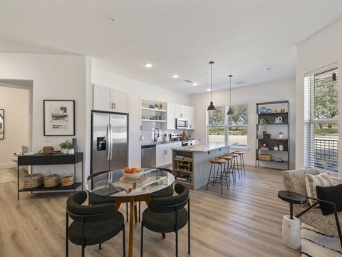 an open kitchen and living room with a table and chairs